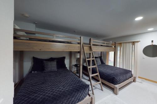 a bedroom with two bunk beds and a ladder at The Avon Spot in Avon