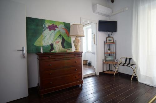 a room with a dresser with a lamp and a painting at Cittadella Rooms in Salerno