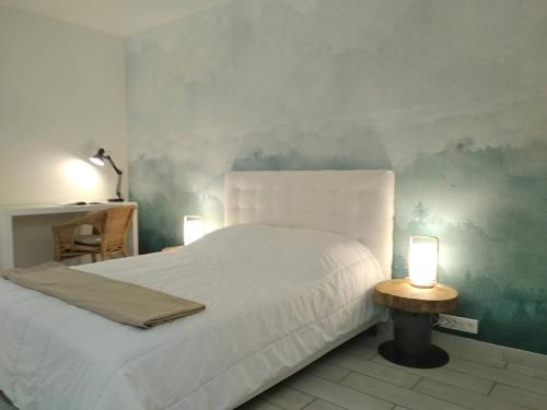 a bedroom with a white bed and two lamps at Le Baionarena 4 pers-terrasse-parking-hypercentre in Labenne