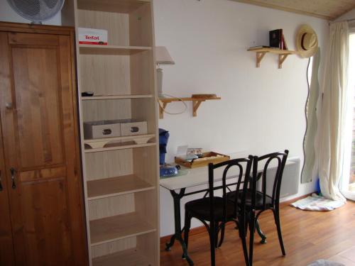 a room with a table and chairs and a table and shelves at MER à pied Vrai lit LINGE FOURNI Jardin LOCAL vélos in Brétignolles-sur-Mer
