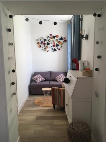 a living room with a purple couch and a table at L auberge du lion d or in Nanteuil-sur-Marne