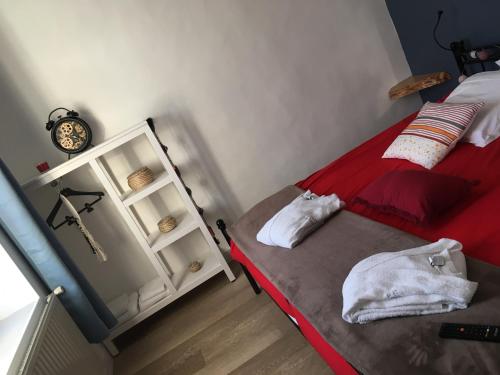 a bedroom with a red bed and a white cabinet at L auberge du lion d or in Nanteuil-sur-Marne