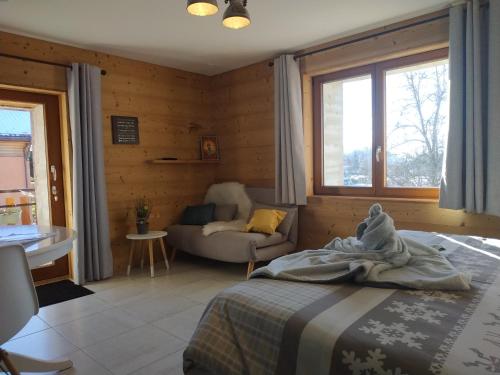 een slaapkamer met een bed en een bank in een kamer bij Maison d'hôtes des Bassins d'Oche in Saint-Paul-en-Chablais