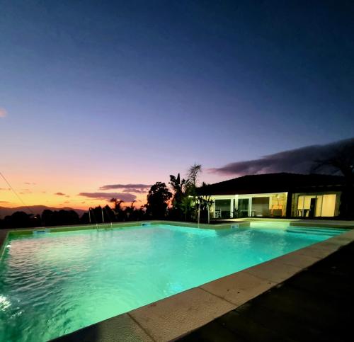 a swimming pool at night with the sun setting at Recanto Nature in Vila Verde