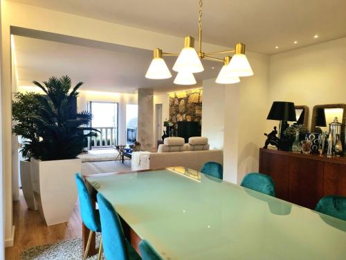 a living room with a table and blue chairs at Recanto Nature in Vila Verde