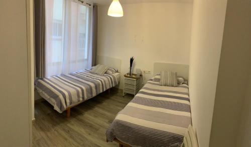 two beds in a room with a window at Delante del Mar in Lloret de Mar
