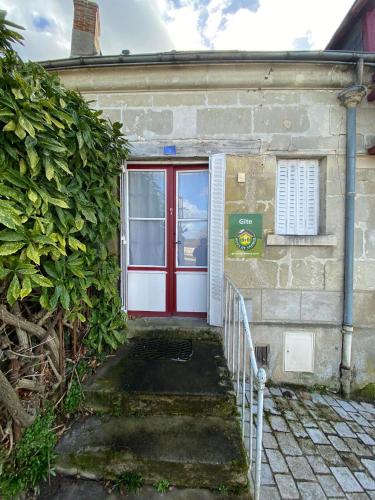a red door on the side of a building at Chez Benjamin - Les Terrasses de Villandry in Villandry