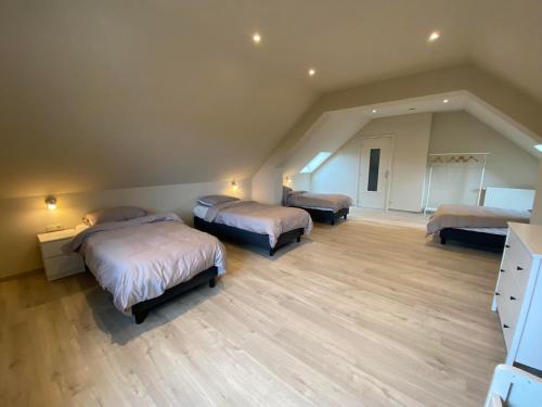 een slaapkamer met 3 bedden op een zolder bij 't Cappellelandhof in Lo-Reninge