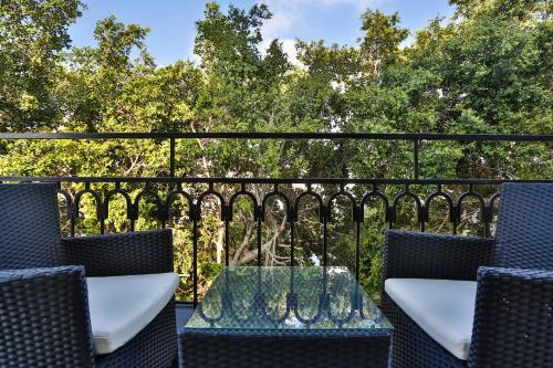 a table and chairs on a balcony with trees at Dizengoff Avenue Boutique Hotel in Tel Aviv