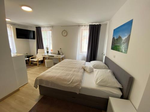 Schlafzimmer mit einem Bett, einem Schreibtisch und einem Tisch in der Unterkunft Gostisce Sovdat in Bovec