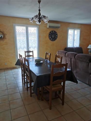 une salle à manger avec une table, des chaises et un canapé dans l'établissement Belle villa de 90m2 au calme avec jardin et parking à 10 mn de la mer en voiture, à Fos-sur-Mer