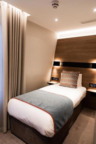 Ένα ή περισσότερα κρεβάτια σε δωμάτιο στο Merit Kensington Hotel