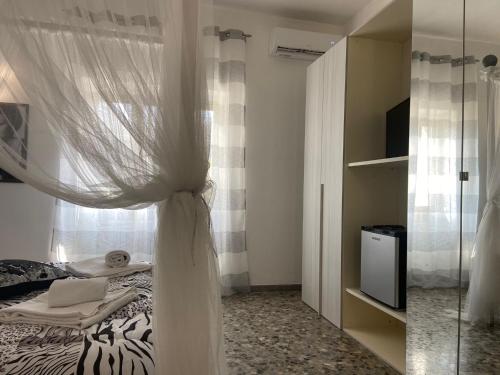 a bedroom with a bed with a curtain and a window at House Villa Anna in Polignano a Mare
