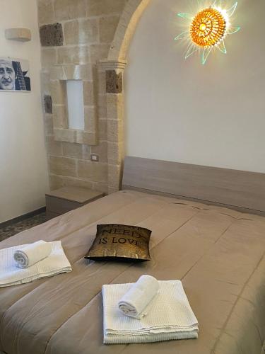 a bedroom with a bed with towels and a light at House Villa Anna in Polignano a Mare