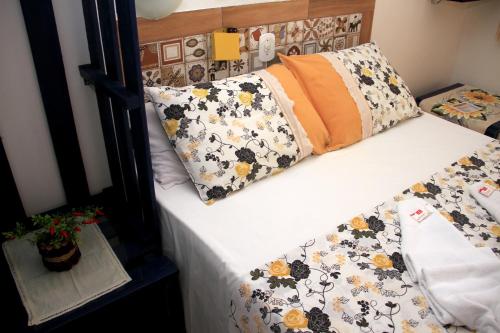 un letto con sopra dei cuscini floreali di Camping e Chalés Beira Mar a Maragogi