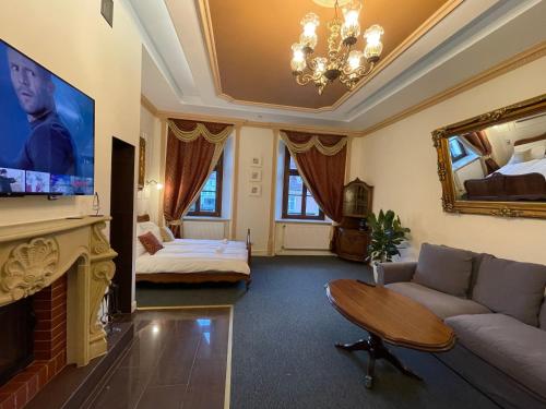 a living room with a couch and a tv at Apartamenty Stary Browar Oleśnica in Oleśnica