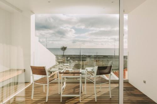 a dining room with a table and chairs on a balcony at Coast View by Azores Villas in Ponta Delgada