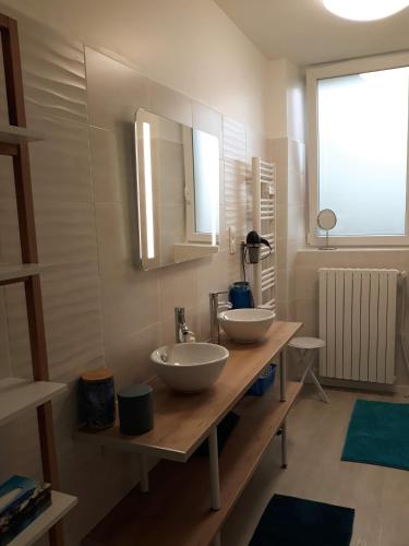 deux lavabos sur un comptoir en bois dans une salle de bain dans l'établissement GÎTE DU BOUYSSOU, à Carsac-Aillac