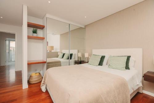 sypialnia z dużym białym łóżkiem i lustrem w obiekcie Coast Flats by Azores Villas w mieście Ponta Delgada
