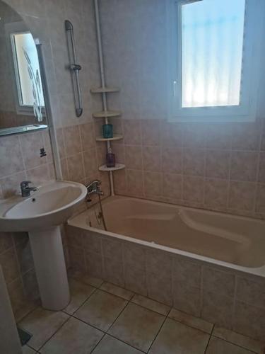une salle de bain avec un lavabo et une baignoire et un lavabo dans l'établissement Belle villa de 90m2 au calme avec jardin et parking à 10 mn de la mer en voiture, à Fos-sur-Mer
