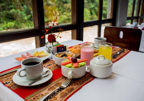 un tavolo per la colazione con caffè, frutta e bevande di Hatun Inti Boutique a Machu Picchu