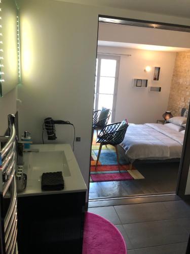 a bedroom with a bed and a sink and a mirror at Les Halles Chambre D'hôtes in Verteuil-sur-Charente