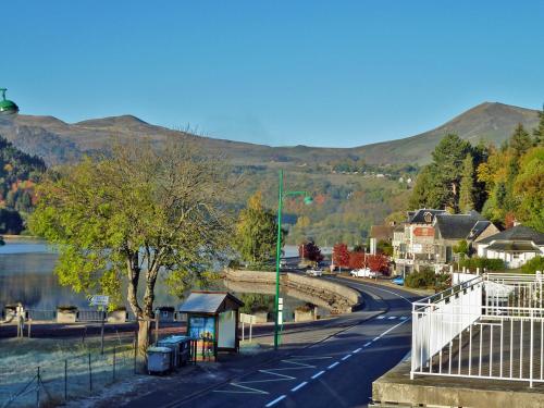 a road in a town with a river and a bridge at GÎTE GUERY in Chambon-sur-Lac