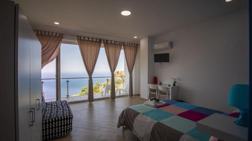 1 dormitorio con cama y vistas al océano en Talè Gioiosa en Gioiosa Marea