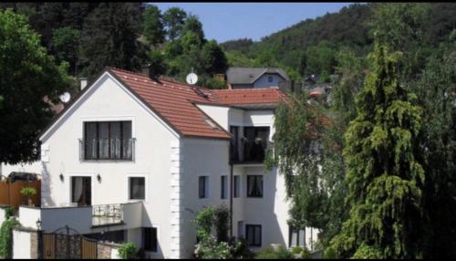 a white house with a red roof on a hill at Pension Artstetten in Artstetten