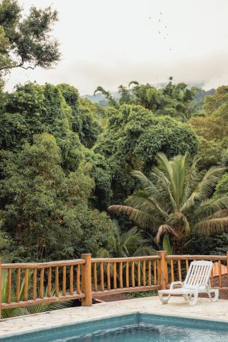 a swimming pool next to a wooden fence and a chair at Diver Village Ilhabela in Ilhabela
