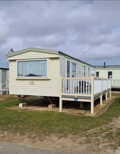 a mobile home with a porch and a house at 5 Berth promenade Sahara II in Ingoldmells