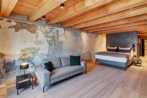 a bedroom with a bed and a couch in a room at Boutiquehotel Rattenberg in Rattenberg