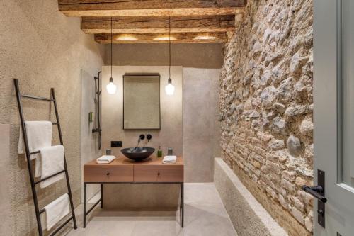 a bathroom with a sink and a stone wall at Boutiquehotel Rattenberg in Rattenberg