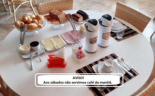 een witte tafel met ontbijtproducten erop bij Paraíso do sul - Shangrilá in Pontal do Paraná