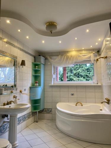 a bathroom with a tub and a sink at Ach to tu in Malbork