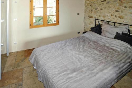 duże łóżko w sypialni z oknem w obiekcie holiday home, Sainte-Croix-du-Verdon w mieście Sainte-Croix-de-Verdon