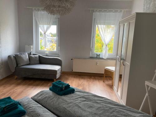 un soggiorno con un letto e un divano e due finestre di Schöne Zweiraumwohnung in Cottbus a Cottbus