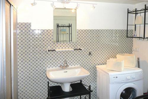 une salle de bain avec un lavabo et une machine à laver dans l'établissement Stone House in Brittany with Sea Views, à Plougasnou