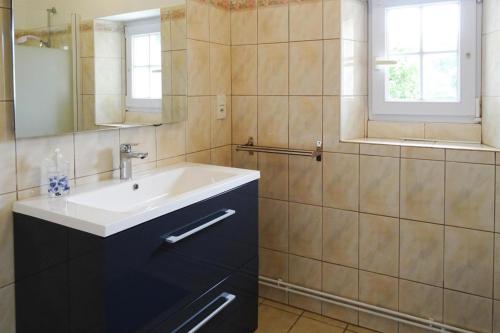 une salle de bain avec un lavabo et un miroir dans l'établissement Stone House in Treboul near Pointe du Raz, à Douarnenez