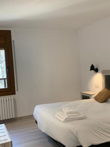 a bedroom with a bed with two towels on it at PASSAMANÉ 19 - Canillo - Casco Antiguo Hut 7867 in Canillo