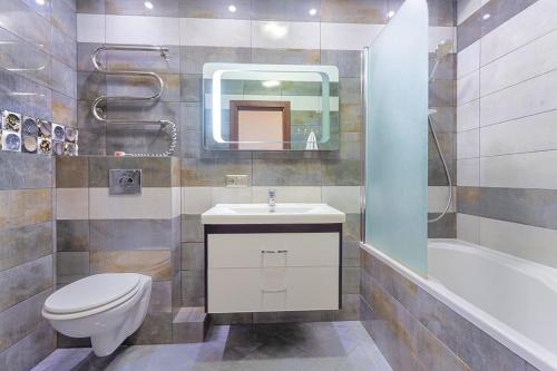 a bathroom with a toilet and a sink and a tub at Роскошная 3к квартира 125м2 на набережной in Kyiv