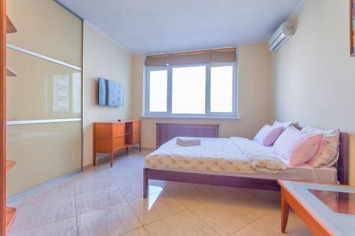 a bedroom with a bed and a window at Роскошная 3к квартира 125м2 на набережной in Kyiv
