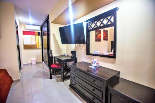 a room with a dresser and a desk and a mirror at Hotel Plaza Mirador in Mérida