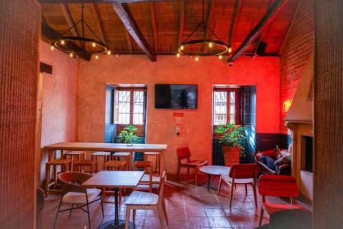 un restaurant avec des tables, des chaises et des murs rouges dans l'établissement Masaya Bogotá, à Bogotá