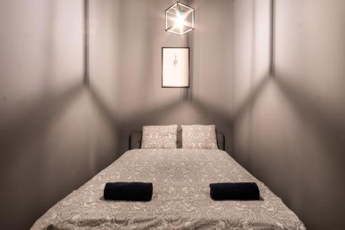 um quarto com uma cama com duas almofadas em Revolution Aparts - Studio em Lódź