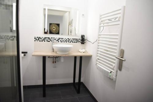 La salle de bains est pourvue d'un lavabo et d'un miroir. dans l'établissement Studio de charme RDC, à Boulogne-sur-Mer
