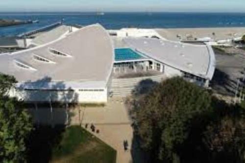 un grand bâtiment blanc à côté de l'océan dans l'établissement Studio de charme RDC, à Boulogne-sur-Mer