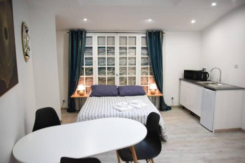 une chambre avec un lit et une table avec des chaises dans l'établissement Studio de charme RDC, à Boulogne-sur-Mer