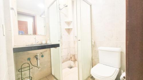 a white bathroom with a toilet and a sink at Apt no Taiba Beach Resort in Taíba