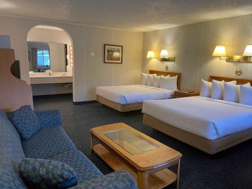 a hotel room with two beds and a couch at Ranch Inn Jackson Hole in Jackson
